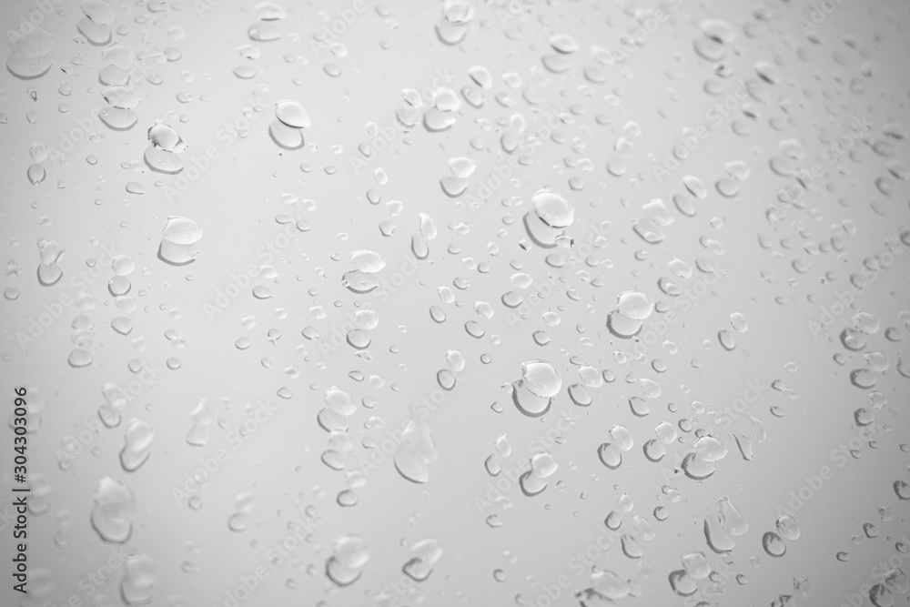 Raindrop water dew drop on glass wet white gray blue background.