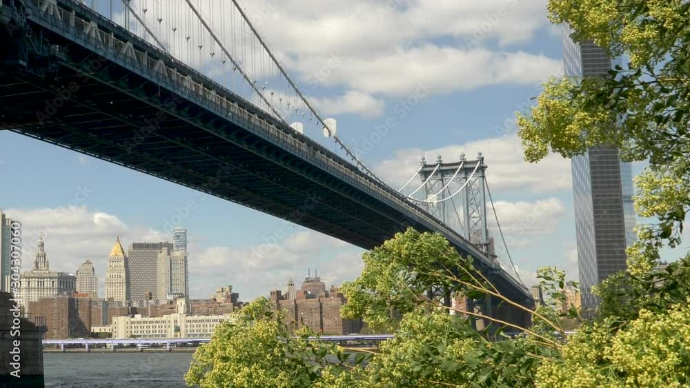 Zoom in through NYC East River to Manhattan Bridge Base and nearby Skyscrapers Zoom in through NYC East River to Manhattan Bridge Base and nearby Skyscrapers