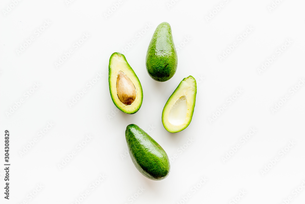 Avocado - ripe and bright, cutted in half - on white background top view copy space Avocado - ripe and bright, cutted in half - on white background top view copy space