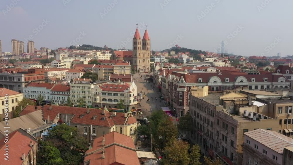 Beautiful aerial view of colonial era (German) Saint Michael's Cathedral in historic residential and commercial neighborhood in Qingdao, religion tourism architecture in China Beautiful aerial view of colonial era (German) Saint Michael's Cathedral in historic residential and commercial neighborhood in Qingdao, religion tourism architecture in China