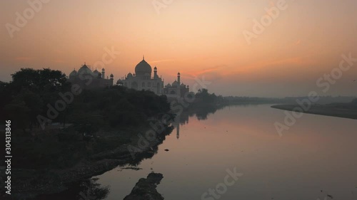 taj mahal in Agra UNESCO site in India view from Yamuna river during sunrise. photo