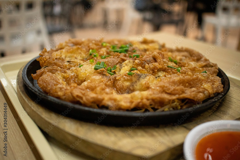 Thai style Oyster Omelette on hot pan served in food court. Thai style Oyster Omelette on hot pan served in food court.