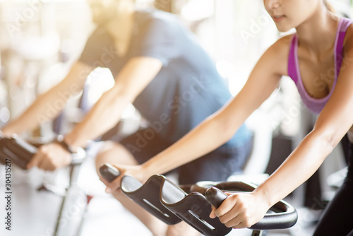 Young healthy woman and man bike cardio at the gym.