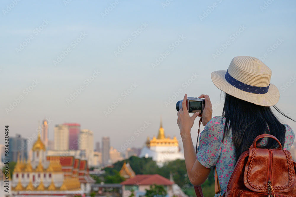 tourist in action and exciting in takes photo with the golden temple of wat saket, the popular tourist place in Bangkok Thailand