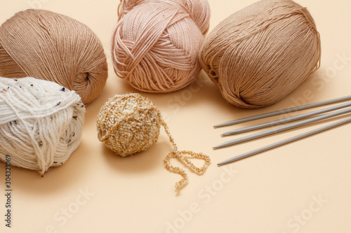 Woolen yarns for knitting. Balls of natural wool yarn and knitting needles.