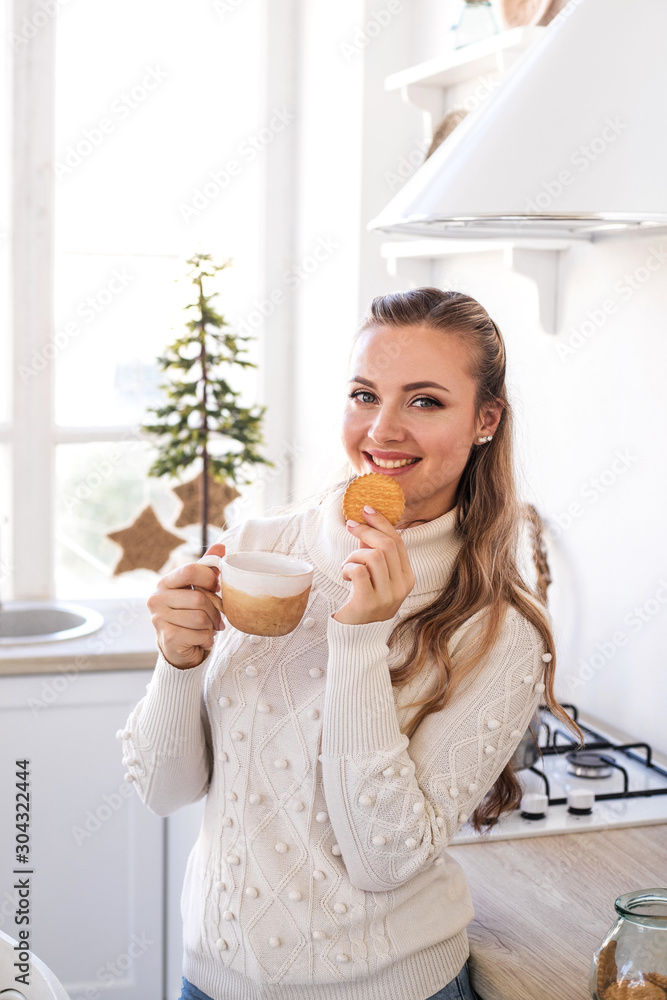 Beautiful young woman drink tea at the festive kitchen. Christmas and New year concept. Beautiful young woman drink tea at the festive kitchen. Christmas and New year concept.