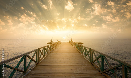 Fototapeta Naklejka Na Ścianę i Meble -  Wooden pier on sea at morning sunrise