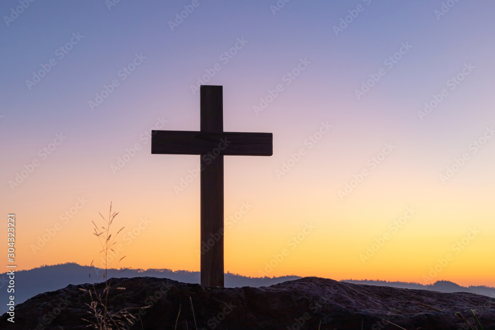 cross crucifixion of the crucifixion of jesus christ on a mountain with a sunset sky background