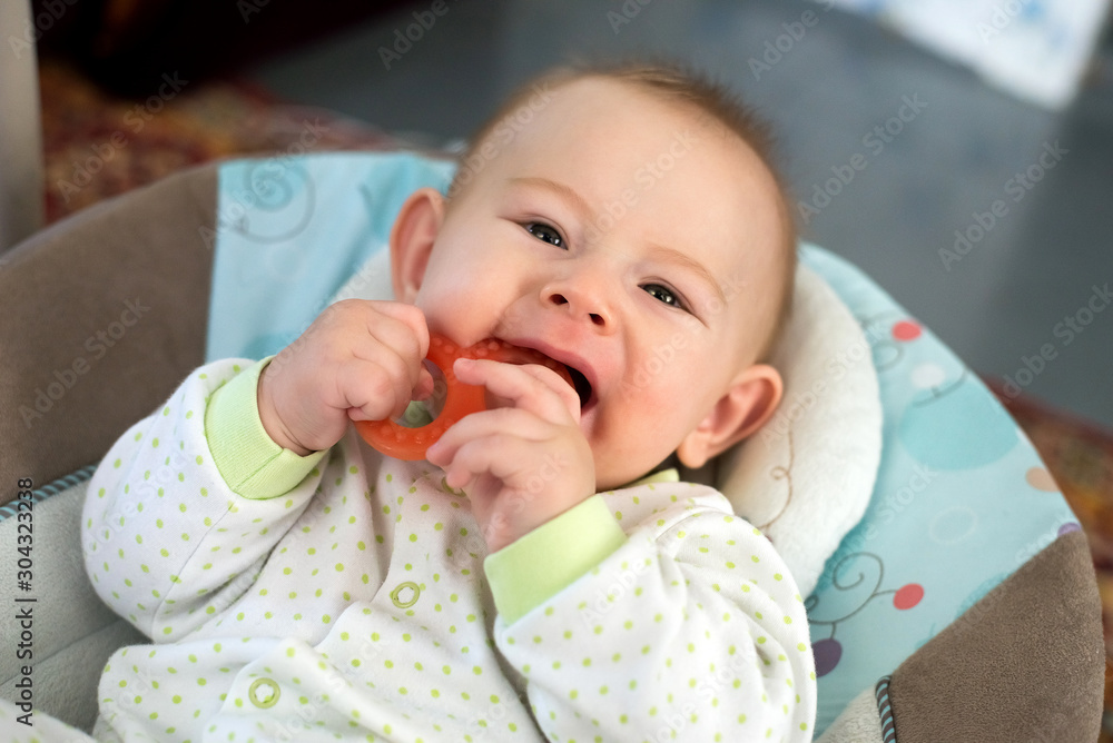 Little 5 months baby boy sitting and playing teething toy at home Little 5 months baby boy sitting and playing teething toy at home