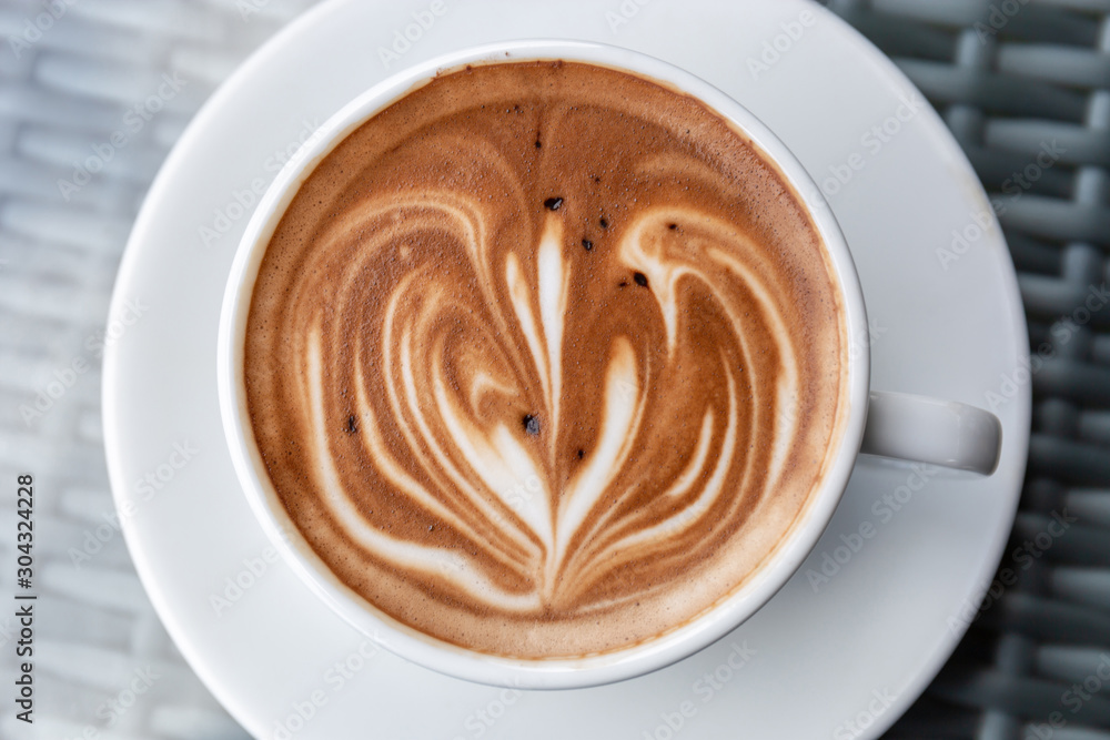 Hot latte art coffee heart shape in a white cup on table Hot latte art coffee heart shape in a white cup on table