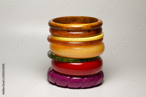 Close up view of vintage bakelite bangle bracelets in varying colors and widths on white background