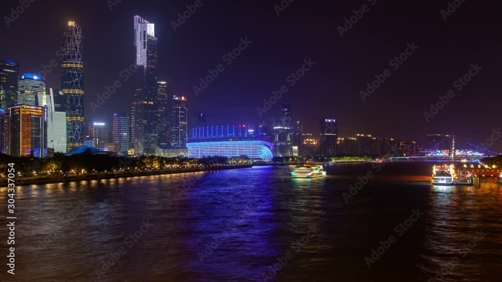 Timelapse illuminated motorboats sail along wide calm Pearl river with Guangzhou city reflection in Guangdong province of China at dark night Timelapse illuminated motorboats sail along wide calm Pearl river with Guangzhou city reflection in Guangdong province of China at dark night