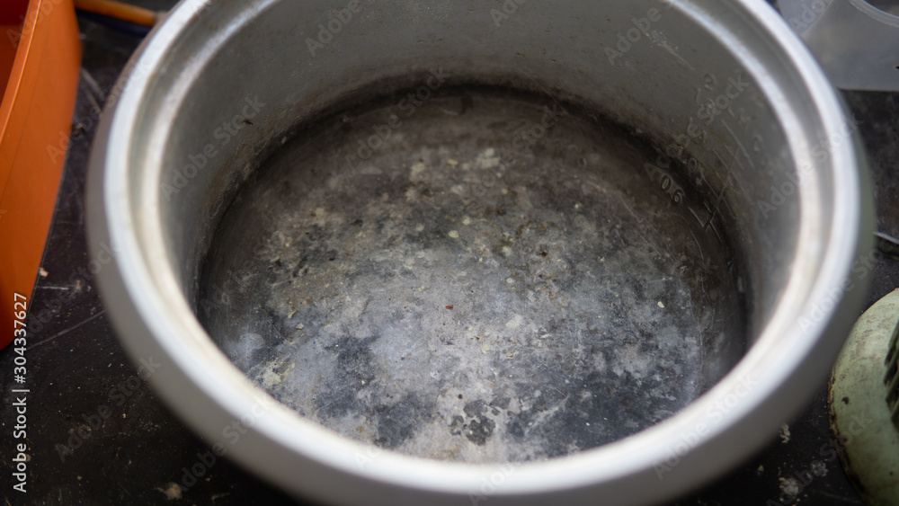 Close up view of the old unused and dirty rice cooker at the kitchen. Food stain inside the rice cooker.