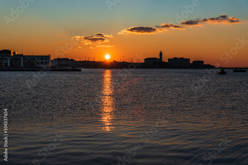 Sunset from the Audace pier of Trieste. Colors of fire on the water. Italy