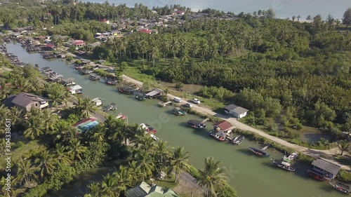 Aerial view of fisherman village with boats dock at the river estuary nearby.