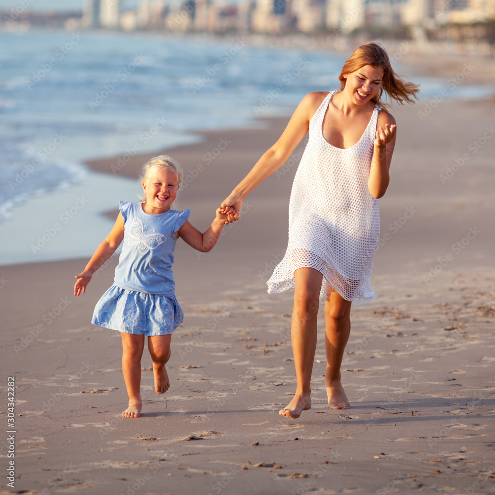 Portrait of happy sisters. They hug on the background of the sea.