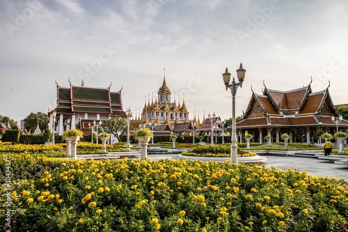 Wat Ratchanatdaram Woravihara (Loha Prasat) with yellow flowers during coronation celebrations of His Majesty King Maha Vajiralongkorn Bodindradebayavarangkun (King Rama X), Bangkok, Thailand