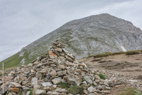 A huge pile of stones guiding the way to Vihren peak, national park Pirin. Beautiful bulgarian mountains. Selective focus. Vihren peak at background. © RaDa