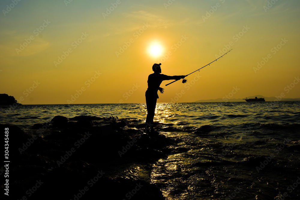 fisherman silhouette with sunset and sea scenery