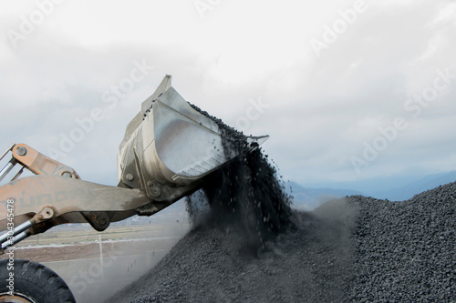 Excavator machine doing excavation earthmoving work in black sand