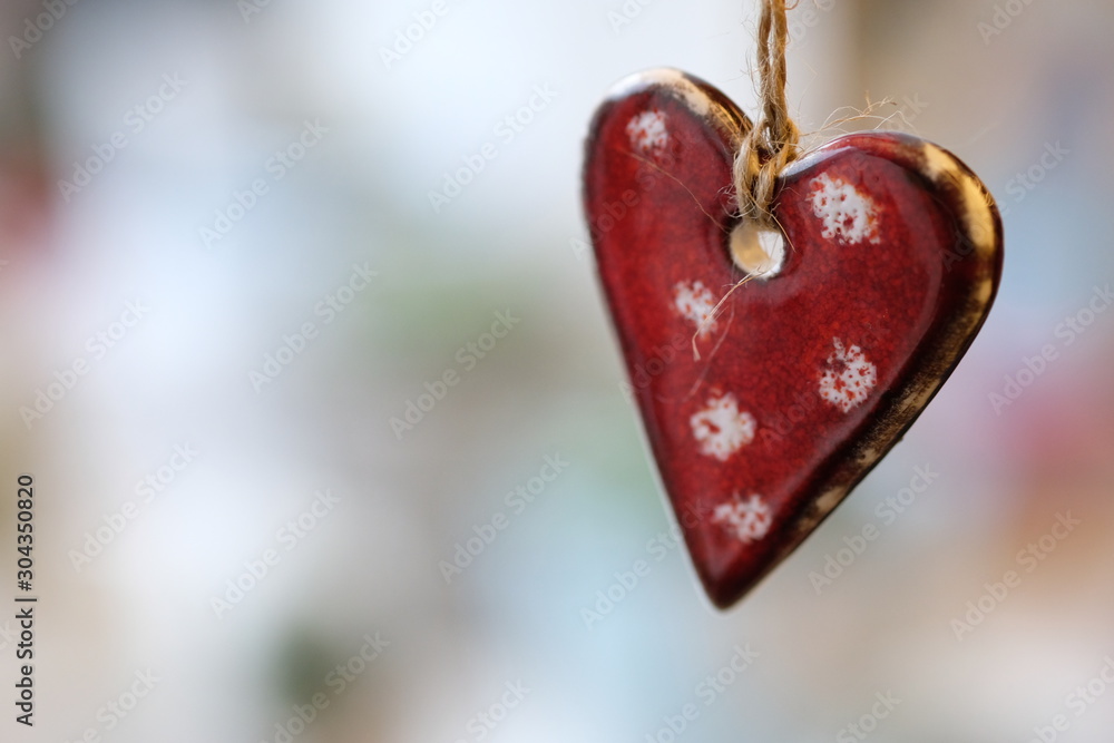 Christmas decor red ceramic heart, ornament hanging on sacking threads Christmas decor red ceramic heart, ornament hanging on sacking threads