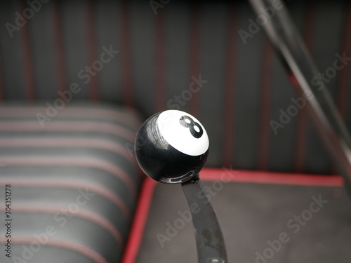 the shift lever of an automatic transmission of a vehicle with installed black pool ball as a handle. figure 8 on white background