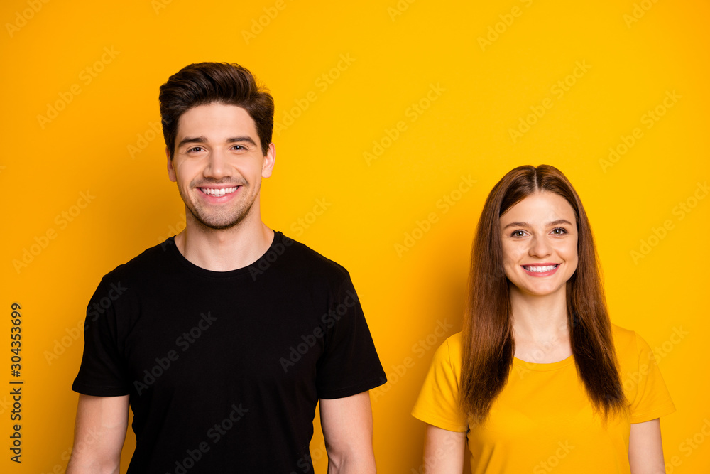 Photo of cheerful toothy beaming positive cute nice couple standing side by side smiling isolated over shiny bright color background Photo of cheerful toothy beaming positive cute nice couple standing side by side smiling isolated over shiny bright color background