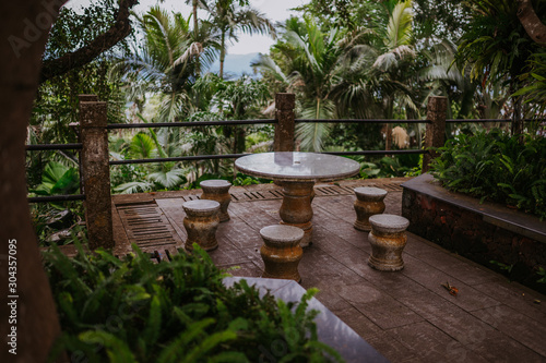 Stone round table and chairs in a tropical bar outdoors among tropical trees and palms in the nature park