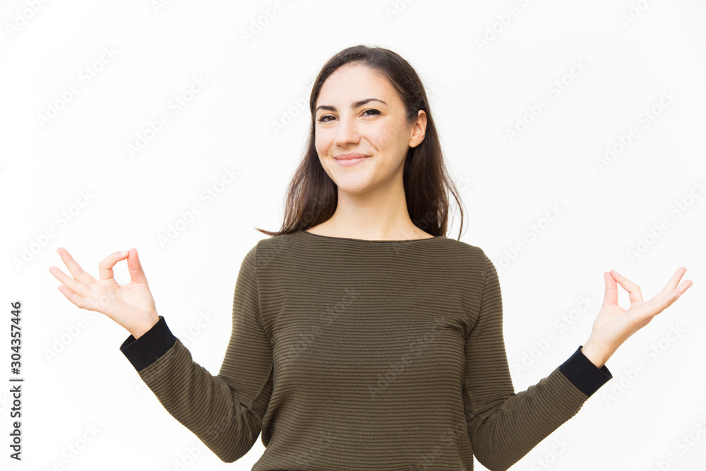 Happy positive female student making zen gesture with hands. Young woman in casual and virtual reality glasses standing isolated over white background. Emotion balance concept Happy positive female student making zen gesture with hands. Young woman in casual and virtual reality glasses standing isolated over white background. Emotion balance concept