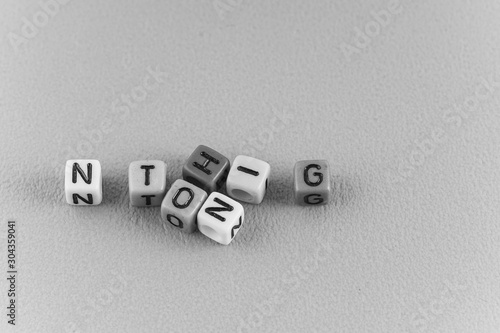 A word NOTHING made by a colourful cube beads alphabet . Black and white concept