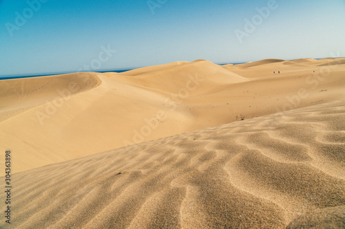 Low shot sand dunes in Maspalomas  Las Palmas of Gran canaria  tropical Canary island in Atlantic ocean  Spain  people in distance