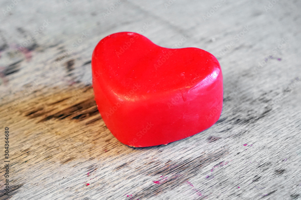 Fototapeta premium A head of red Dutch cheese in the shape of a heart lies on a wooden board in a private dairy store. St. Valentine's Day. 