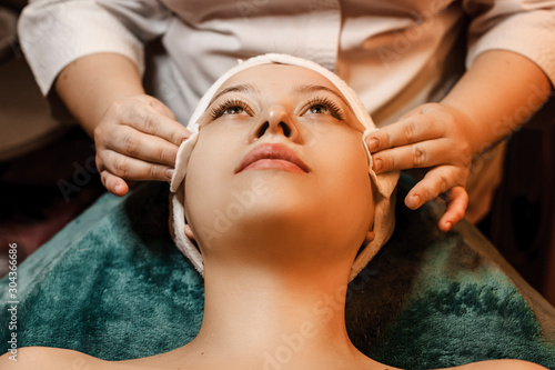 Close up of a lovely female having skin care procedures in a wellness spa center.