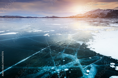 Blue ice on the frozen lake at sunset. Beautiful winter landscape. Bannoye lake in South Ural  Russia