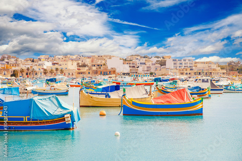 Fisherman port village in Marsaxlokk Malta. Mediterranean traditional retro colorful boats luzzu on summer photo