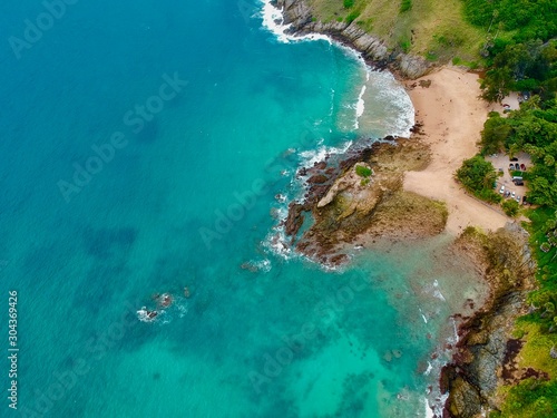 Wind turbine  Panorama drone aerial view electricity windmill overlooking Naiharn beach phuket Thailand turquoise blue waters white golden sandy beach lush green mountains  © Elias Bitar