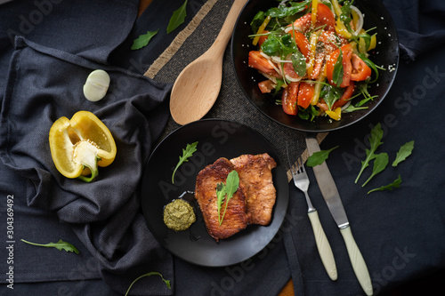 medium beef steaks with pesto sauce and vegetable salad. 