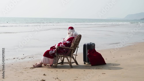 Santa Claus resting on the seashore and looking into the distance