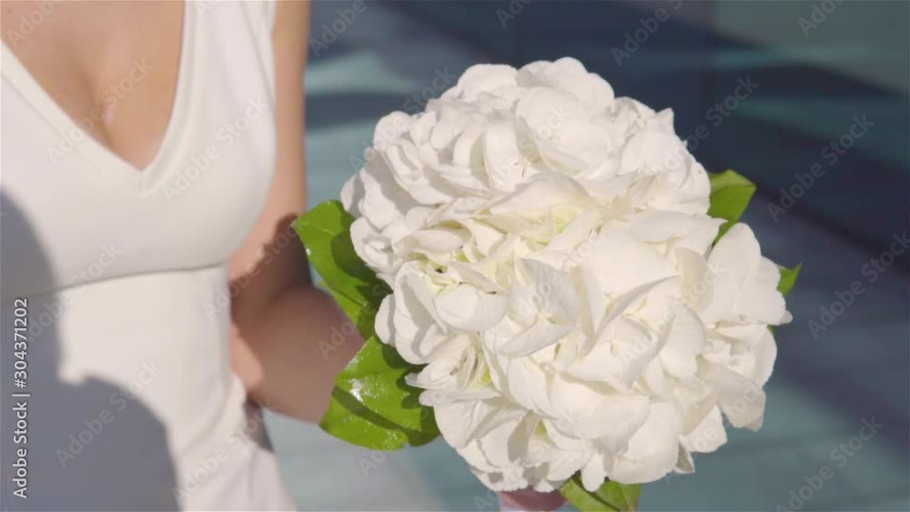 White bouquet of flowers in the hands. Close-up. White bouquet of flowers in the hands. Close-up.