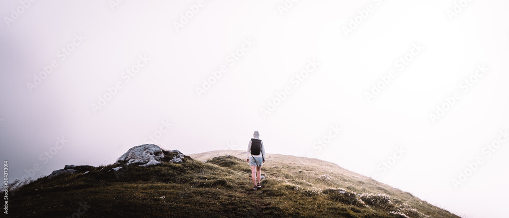 Standing woman on plain covered in fog, Mangart pass