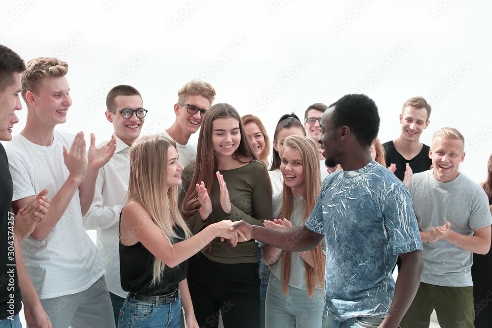handshake of young people on the background of the applauding team handshake of young people on the background of the applauding team