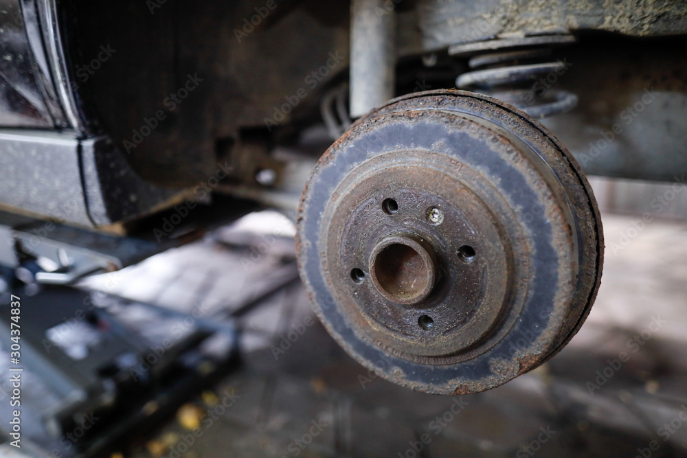 Shallow depth of field (selective focus) image with a rusty rear wheel hub of an old car. Shallow depth of field (selective focus) image with a rusty rear wheel hub of an old car.