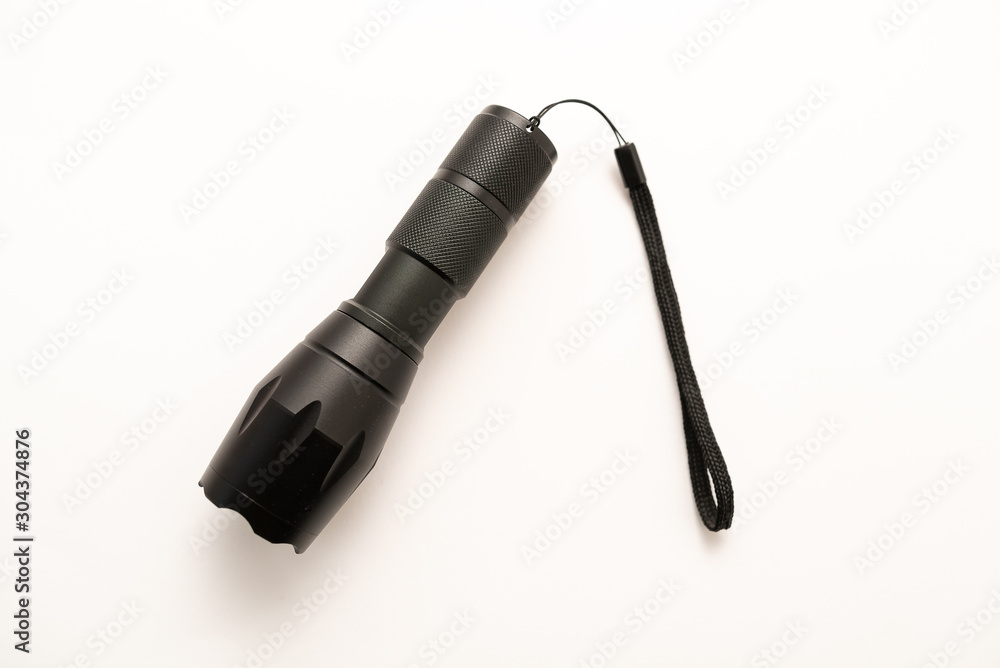 black battery-powered flashlight on white background black battery-powered flashlight on white background