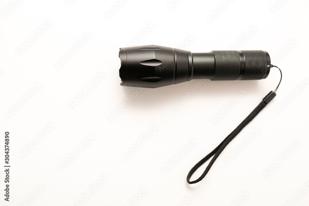 black battery-powered flashlight on white background black battery-powered flashlight on white background