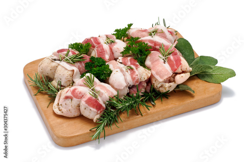 Fotografía Involtini di pollo con pancetta su tagliere di legno