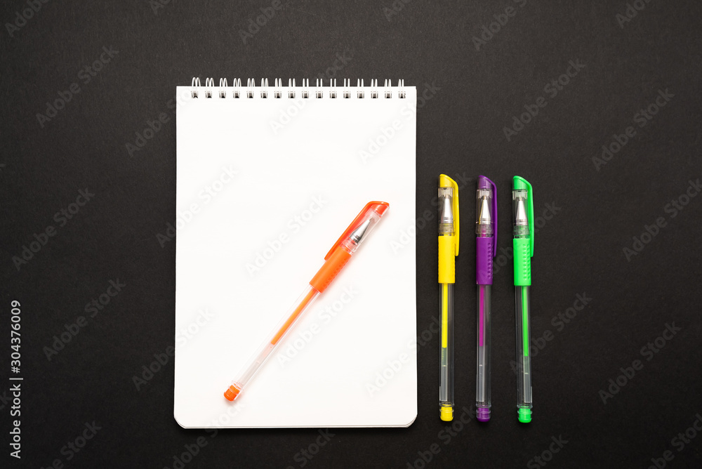 school white notebook with pen on black background school white notebook with pen on black background