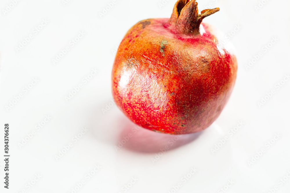 Very ripe pomegranate on white isolated background closeup. Very ripe pomegranate on white isolated background closeup.