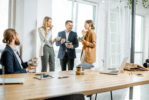 Group of a young office workers during a lunch time in the office. Concept of a healthy takeaway food on the work