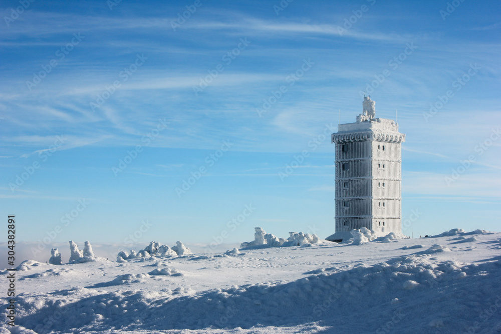 A icy building on Brocken Mountain in Germany. Harz National Park on a snowy day. Winter landscape on a sunny day with blue clear sky A icy building on Brocken Mountain in Germany. Harz National Park on a snowy day. Winter landscape on a sunny day with blue clear sky