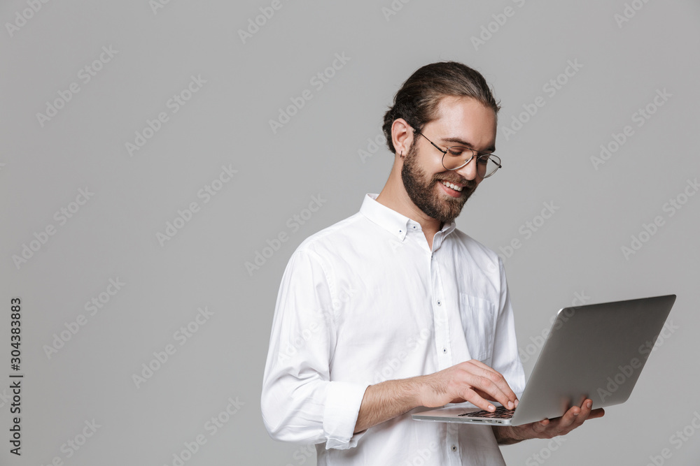 Handsome bearded man wearing glasses using laptop computer.